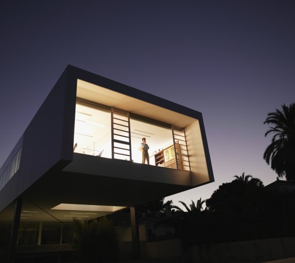 Exterior of a modern office building with man looking out window 